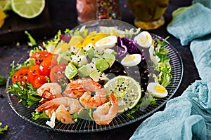 Healthy salad plate. Fresh seafood recipe. Grilled shrimps and fresh vegetable salad - avocado, tomato, black beans, red cabbage a