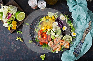 Healthy salad plate. Fresh seafood recipe. Grilled shrimps and fresh vegetable salad - avocado, tomato, black beans, red cabbage a