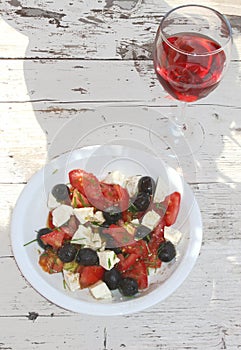 Healthy salad and a wineglass with pink wine