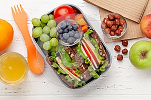 Healthy school lunch box with sandwich and fresh vegetables