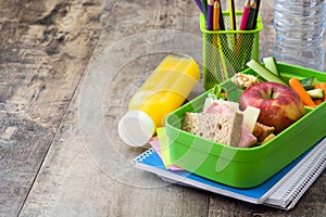 Healthy school lunch: Sandwich, vegetables ,fruit and juice on wood