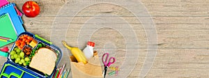 Healthy school lunch and school supplies corner border on a wood banner background