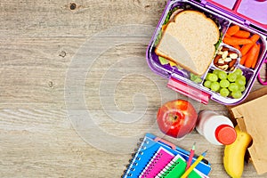 Healthy school lunch and school supplies side border on a wood background
