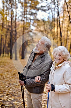 Healthy senior couple hiking in park, exploring. Mature man and woman Happily smiling.