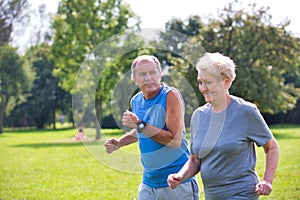 Healthy senior couple jogging in park