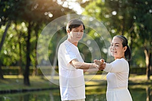 Healthy senior couple practicing Tai Chi Chuan in the morning at the park. Active retirement lifestyle concept