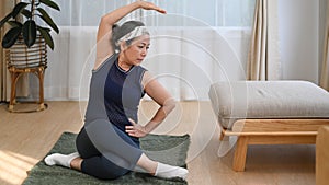 Healthy senior woman doing exercise and stretching on mat at home. Wellness, healthy lifestyle concept