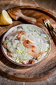 Healthy Shrimp Caesar salad bowl with parmesan cheese and lemon