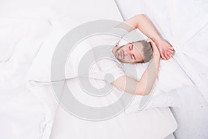 Healthy sleep concept. Tips promoting healthful sleep habits. Handsome man relaxing in bed. Establish regular nightly