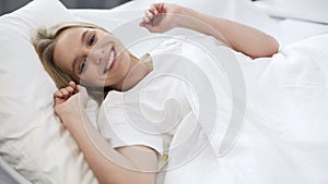 Healthy sleep on orthopedic mattress, happy teenage girl waking up with smile