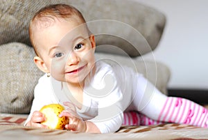 Healthy smiling baby girl with apple in hands