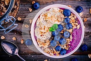 Healthy smoothie bowl with granola, banana and fresh blueberries