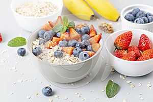 Healthy smoothie bowl with granola, fresh strawberries, blueberries, bananas, yogurt and mint.