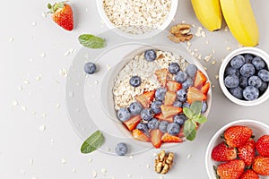 Healthy smoothie bowl with granola, fresh strawberries, blueberries, bananas, yogurt and mint.