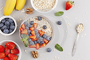 Healthy smoothie bowl with granola, fresh strawberries, blueberries, bananas, yogurt and mint.