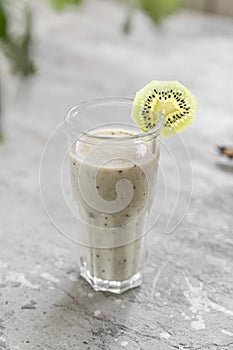 Healthy smoothie made from banana, kiwi and chia seeds on light gray concrete. Vitamin delicious breakfast recipe