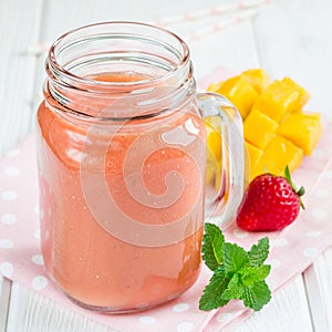 Healthy smoothie with strawberry, mango and banana in glass jars, square format