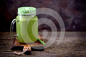 Healthy smoothies in mason jar from spinach, cucumber, celery, apple, parsley with olive oil, Himalayan rose salt and mineral wate