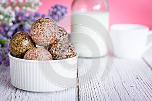 Healthy snack. Energy ball with date plam, black and white sesame, chia and rasin in ceramic bowl on wooden table. Vegan