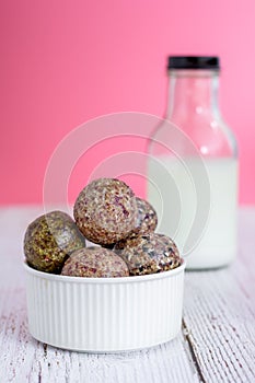 Healthy snack. Energy ball with date plam, black and white sesame, chia and rasin in ceramic bowl on wooden table. Vegan