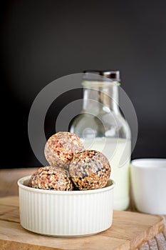 Healthy snack. Energy ball with date plam, black and white sesame, chia and rasin in ceramic bowl on wooden table. Vegan