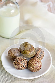 Healthy snack. Energy ball with date plam, black and white sesame, chia and rasin in ceramic palte on table. Vegan vegetarian