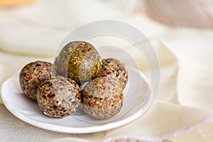 Healthy snack. Energy ball with date plam, black and white sesame, chia and rasin in ceramic palte on table. Vegan vegetarian