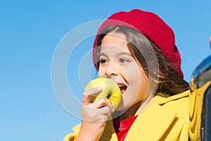 Healthy snack for a kid. Cute child eating healthy fruit on sunny day. Little girl biting into juicy green apple for