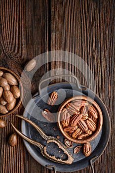 Healthy snack rich in vitamins and minerals, fresh shelled and in-shell pecans in a bowl with copy space