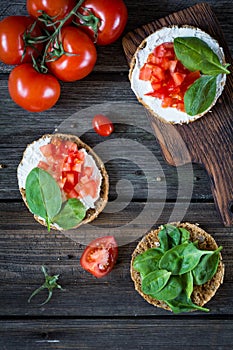 Healthy snack with spinach, tomato, ricotta and whole grain bread
