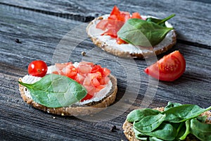 Healthy snack with spinach, tomato, ricotta and whole grain bread