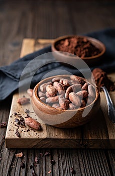 Healthy snack, superfood unroasted cocoa beans in a wooden bowl