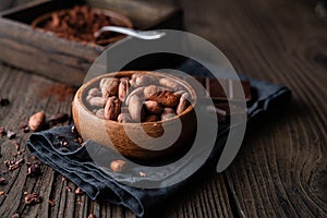 Healthy snack, superfood unroasted cocoa beans in a wooden bowl