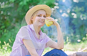 Healthy snack. Woman straw hat sit meadow hold apple fruit. Healthy life is her choice. Girl at picnic in forest on