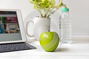 Healthy snack with working in the office. Green apple and fresh water