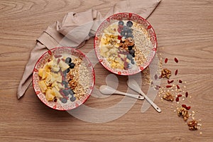 Healthy snacks in bowl: yoghurt, oat flakes, fruit, chia and goji seeds