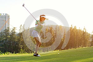 Healthy Sport. Asian Sporty woman golfer player doing golf swing tee off on the green, people presumably does exercise.