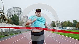 Healthy and sport lifestyle obese man running excited to the finish line at the running marathon he are very excited and