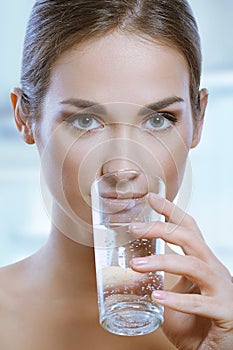 Healthy sport woman drinking cold water from glass