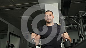 Healthy sports athlete of Caucasian appearance does another exercise in the gym