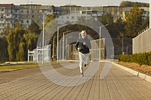 Healthy sporty fitness mature man running outdoors training for wellness, health and cardio
