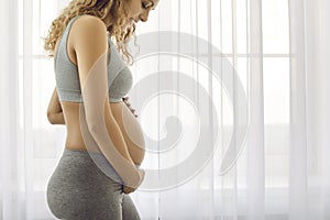 Healthy sporty pregnant woman caress bump