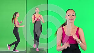 Healthy sporty young woman running and looking at smart watch device on a Green Screen, Chroma Key.