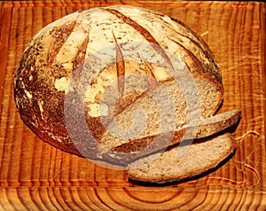 Healthy stone baked organic sourdough bread on an old wooden board