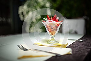 Healthy strawberries and cream refreshing light dessert.Whipping cream with strawberry pieces served in elegant glass cup.Homemade