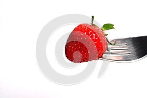 Healthy Strawberry impale with stanley fork on white isolated background photo