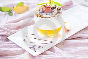 Healthy strawberry, peach and walnut parfait in a glass on a white background