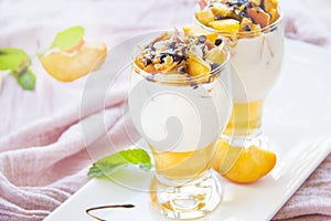 Healthy strawberry, peach and walnut parfait in a glass on a white background