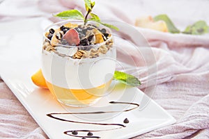 Healthy strawberry, peach and walnut parfait in a glass on a white background