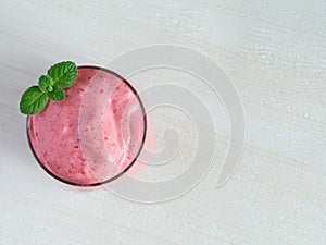 Healthy Strawberry or Raspberry Cream mousse in glass on a white wooden table with mint leaves. Delisious summer dessert